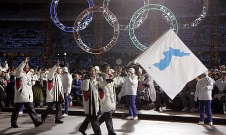 Bora Lee and Jong-In Lee, carrying a unification flag, lead their teams into the stadium during the 2006 Winter Olympics opening ceremony in Turin.