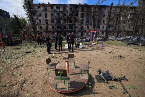 Police officers stand next to the bodies of people killed by a Russian missile strike in Kryvyi Rih.