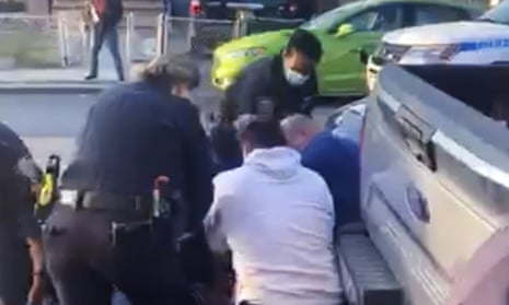 In this 29 April 2020 image made from video provided by Adegoke Atunbi, New York City police officers wrestle a man to the ground while apparently policing social distancing rules in Brooklyn.