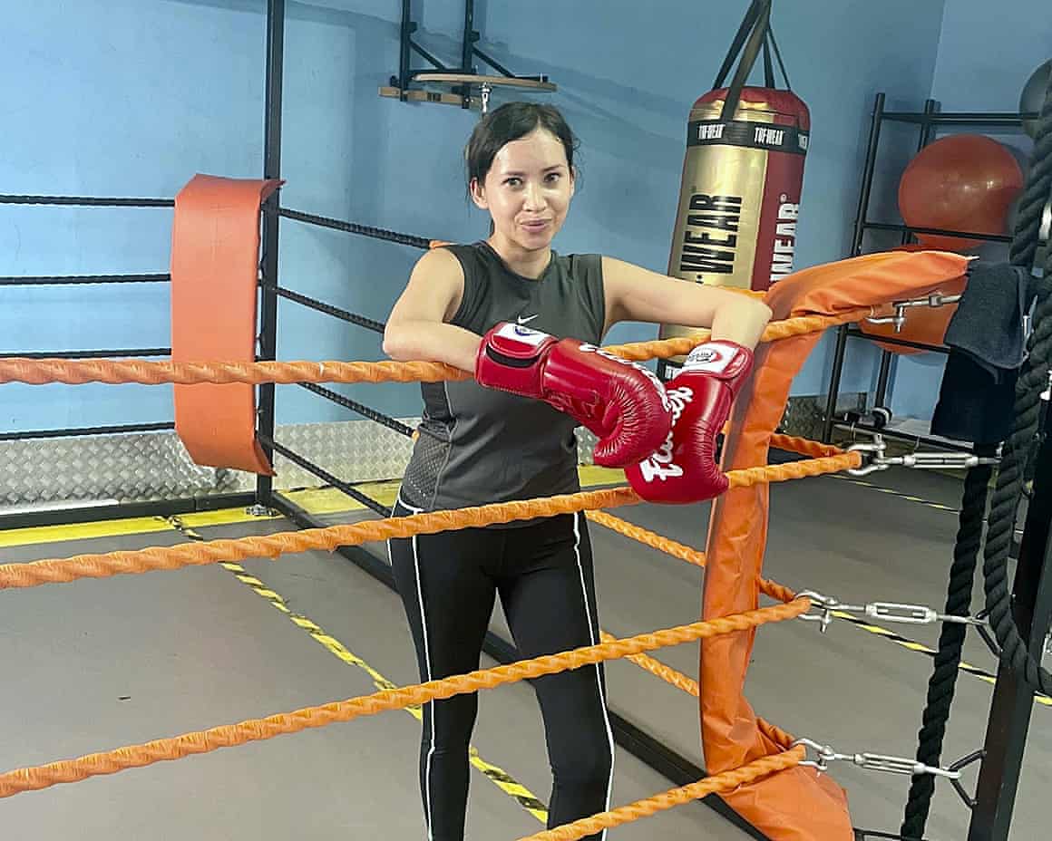 A woman in a boxing ring wearing boxing gloves