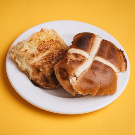 A Waitrose white chocolate & lemon hot cross bun, sliced, toasted and buttered, on a white plate