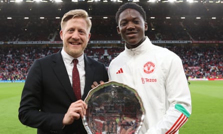 Manchester United’s academy director, Nick Cox, hands graduate Kobbie Mainoo an award.
