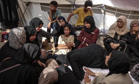 Relatives mourn while gathered around the body of Ahmed al-Sharbasi (who cannot be seen)