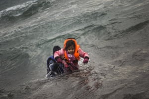 A man and child try to reach shore from the Aegean sea