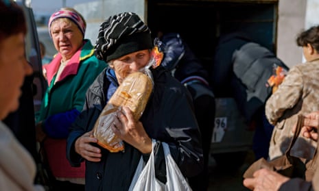 A woman receives a loaf of bread distributed in a village close to frontline in the south of Mykolaiv, Ukraine, 3 November.