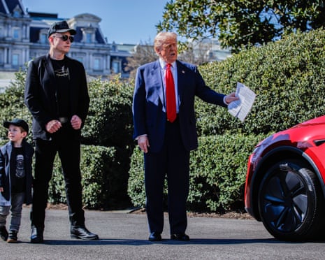 Trump looking at the car with Elon Musk and his son, X.