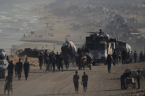 Displaced Palestinians flee Gaza City by foot and vehicles, carrying their belongings along the coastal road toward southern Gaza, on Wednesday.
