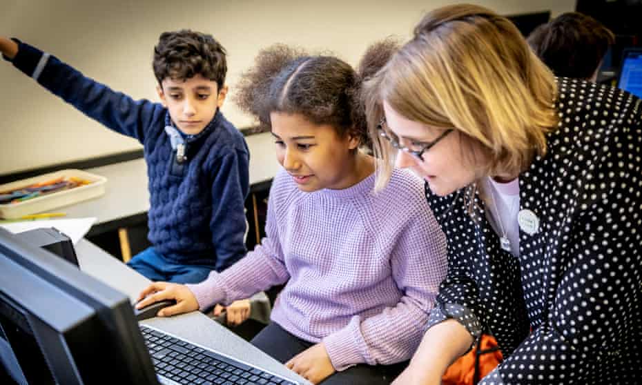 Code Club volunteer with a young boy and girl