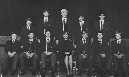 Chess team photo of boys in school uniform, with some seated in front and a second row standing behind, and a woman seated in the centre