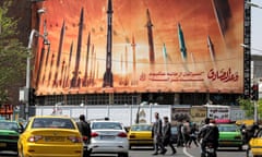 Motorists drive past a billboard depicting Iranian ballistic missiles in Tehran
