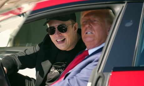 a man in a suit and a man in black clothes sit in a red car