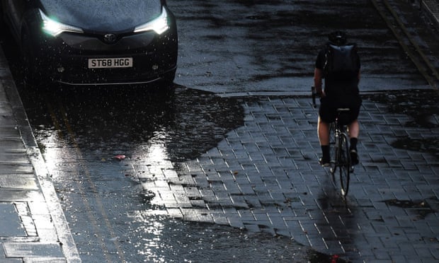 A cyclist rides through the rain in central London on Monday evening.