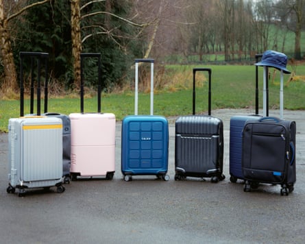 Six different cabin bags, featured in this test, lined up on tarmac at West Leeds Activity Centre on a grey day.