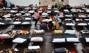 People rest inside a sports hall of a primary school, transformed into temporary accommodation for people fleeing Ukraine, in Przemysl, Poland