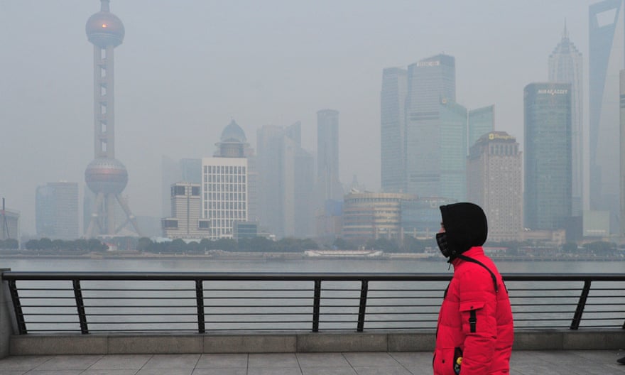A tourist wearing a face mask against air pollution visits the Bund along the river Huangpu in heavy smog in Shanghai, China.