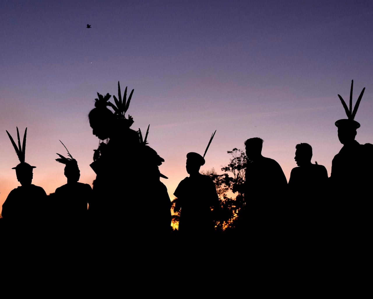 Asháninka Indigenous people in silhouette against the dawn sky