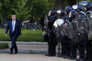 Donald Trump walks past police in Lafayette Park after the visit to St John’s Church across from the White House.