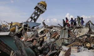 Villagers walk through the wreckage of Palu on the Indonesian island of Sulawesi after last monthâs tsunami and earthquake.