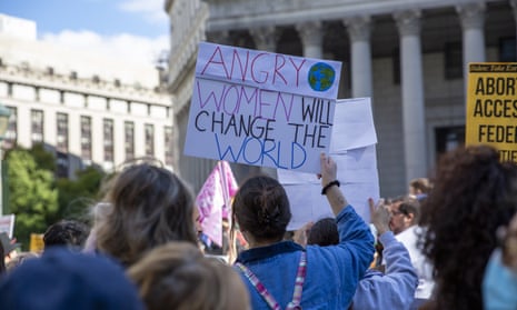 Woman at protest holding sign saying 'angry women will change the world'