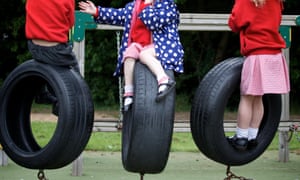 Three schoolchildren playing on swings