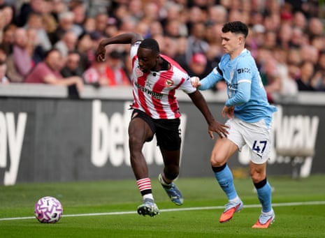 Brentford's Michael Kayode and Manchester City's Phil Foden battle for the ball.