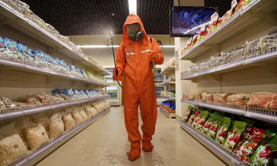 A health official sprays disinfectant as part of preventative measures against Covid-19, in the Daesong Department Store in Pyongyang)