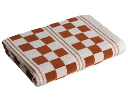 An off folded white beach towel with a brown chequered pattern