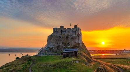 A view of Lindisfarne Castle in summer on the Holy Island of Lindisfarne in Northumberland at sunset looking west from Beblowe Crag2S1A8X7 A view of Lindisfarne Castle in summer on the Holy Island of Lindisfarne in Northumberland at sunset looking west from Beblowe Crag