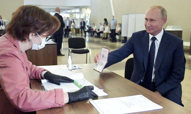 Russian president Vladimir Putin shows his passport as he arrives to vote at a polling station in Moscow. The vote was on constitutional amendments that would enable him to serve two more six-year terms.