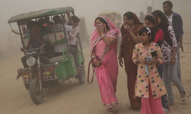 Pedestrians walk in heavy dust and smog in New Delhi at the weekend.