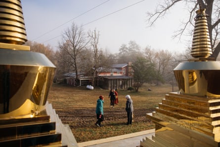 people walk outdoors next to gold structures