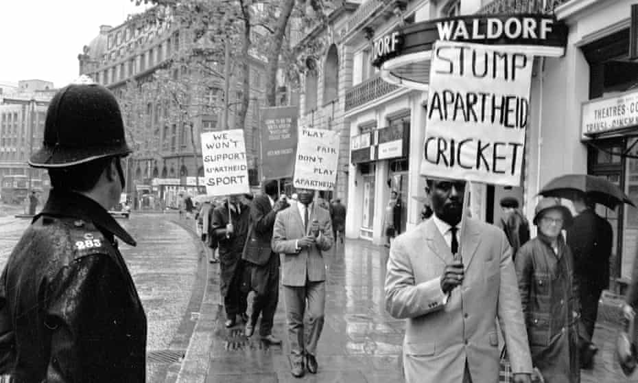 Un policía observa a los manifestantes contra el apartheid fuera del Hotel Waldorf en Londres, donde viven los jugadores de críquet sudafricanos en 1965.