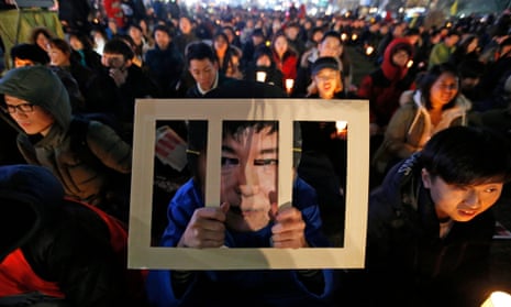 A South Korean wears a Park Geun-hye behind bars-mask while attending a candlelight rally against the president in Seoul.