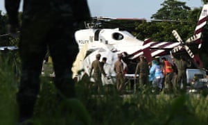 Rescue workers bring a stretcher close to a police helicopter at a military airport in Chiang Rai.