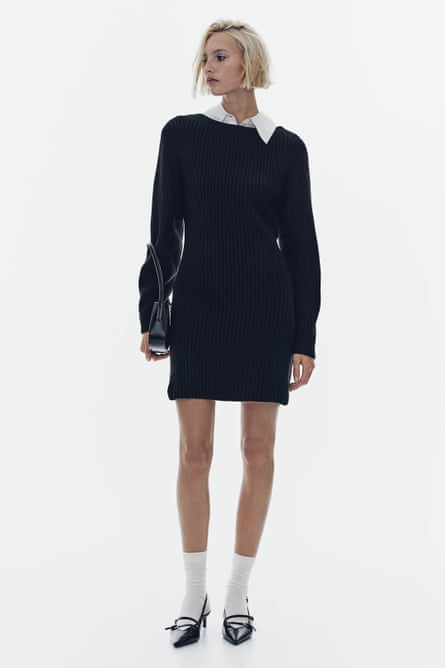 Model wearing an above the knee black knitted dress