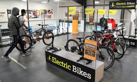 Customers walk past electric bikes in a Halfords store in Luton, UK.