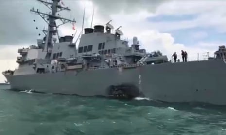 The guided-missile destroyer USS John S McCain returns to port in Singapore on Monday with damage visible on the hull.