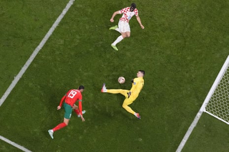 Croatia's goalkeeper Dominik Livakovic saves a shot from Morocco's Youssef En-Nesyri.