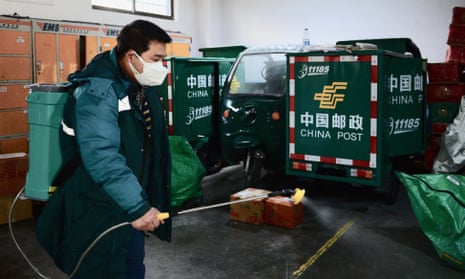 A staff member from a branch of China Post disinfects the warehouse in Xi’an, on 13 January.