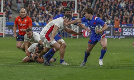 France’s Antoine Dupont fends off an England tackler