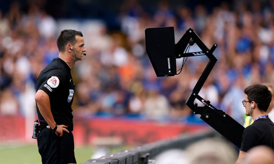 L'arbitro Andrew Madley consulta il monitor a bordo campo per una decisione sul VAR a Stamford Bridge.