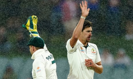 Mitchell Starc and Tim Paine celebrate the wicket of Azhar Ali as rain begins to fall in Adelaide.