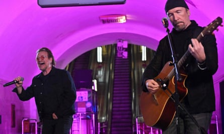 Bono and the Edge perform at the subway station.