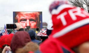 Donald Trump is seen on a screen speaking to supporters during a rally to contest the certification of the 2020 presidential election results in Washington on 6 January.