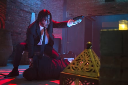 person wearing suit points gun