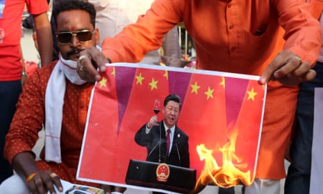 Anti-China protesters in India set alight a picture of the Chinese leader