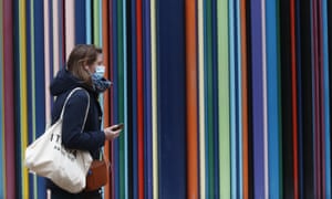 A woman wearing masks to prevent the spread of the coronavirus walk at la Defense business district in Paris, Thursday, 18 March 2021.