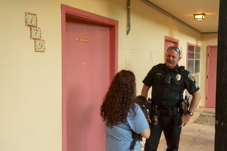 Sgt Thaddeus Allen of the Las Cruces police talks to a woman experiencing a mental health crisis outside her room at a weekly hotel.