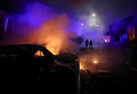 Firefighters work at the site of an apartment building hit by a Russian missile strike in Kyiv.