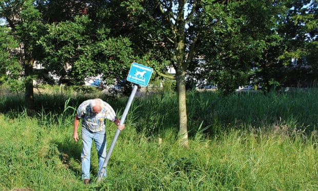 Fixing a crooked signpost on a neighbourhood walk in Spoorwijk.